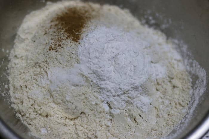 mixing wheat flour, baking powder, salt and cinnamon powder for eggless pancakes recipe
