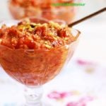 Carrot halwa recipe- a glass bowl containing carrot halwa garnished with fried nuts.