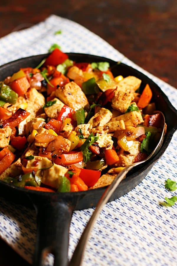 Paneer fry recipe with Indian spices and vegetables served as side dish in a cast iron skillet.