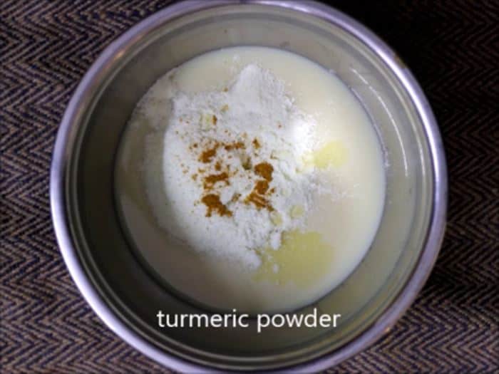 Condensed milk, turmeric milk and milk powder combined in a mixing bowl.