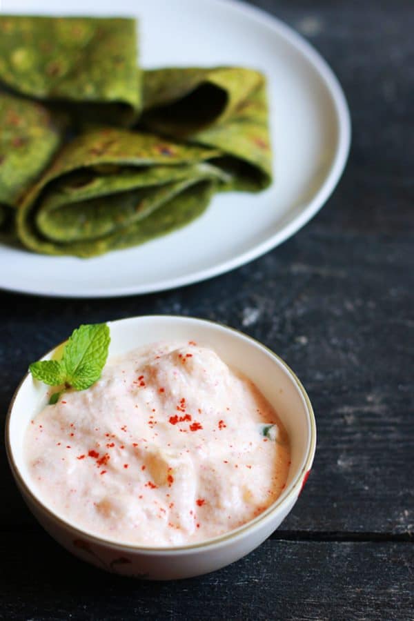 Aloo raita or indian potato salad served with palak paratha