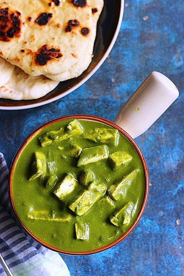 palak paneer served in a bowl with naan