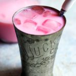 Indian Rose milk recipe served in a tall glass with ice cubes as summer drink