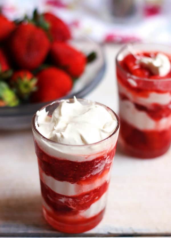 Strawberry cream recipe- A small glass tumbler with strawberry and cream dessert.