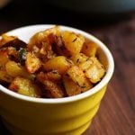 easy to make jeera aloo served in a small ceramic bowl with rice