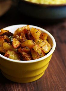 easy to make jeera aloo served in a small ceramic bowl with rice