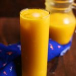 Homemade mango juice recipe with 3 ingredients served in tall glass with ice cubes.