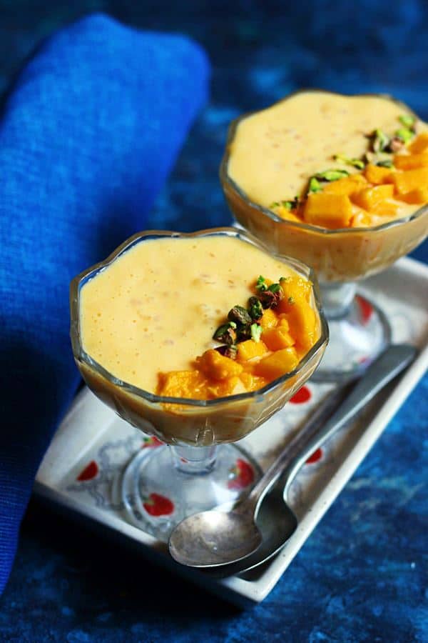 Two bowls of mango sago dessert served in a white tray with spoons