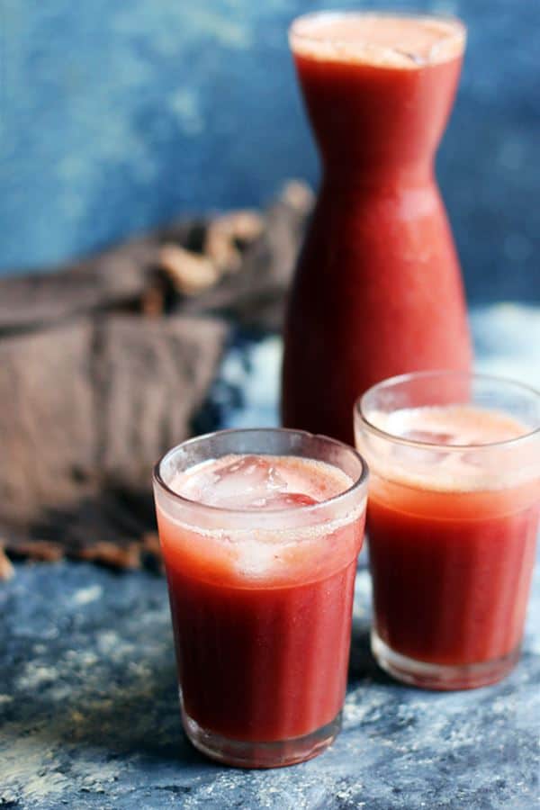 Two servings of fresh grape juice in small glass tumblers