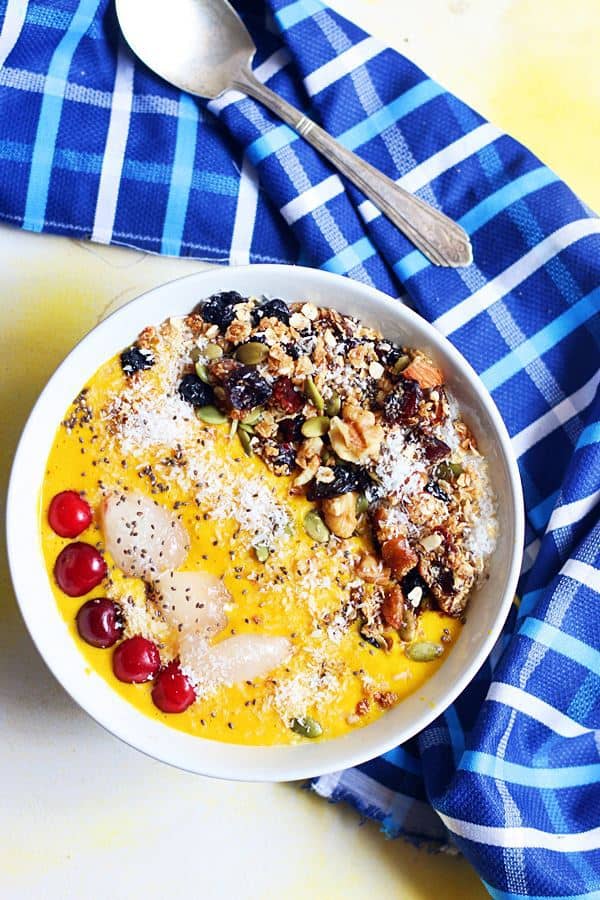 Overhead shot of mango smoothie bowl served with a spoon
