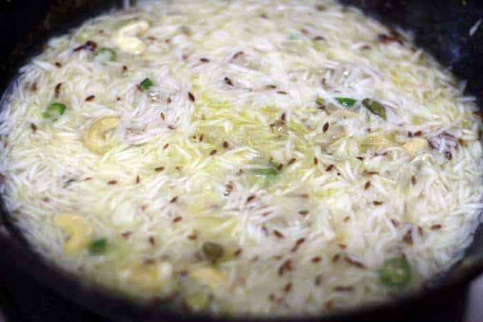 Cooking jeera rice in pot.