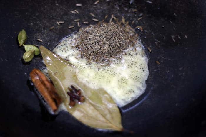 sauteing cumin seeds in ghee for making zeera rice