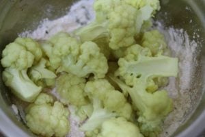 Tossing cauliflower in batter for making crispy fried cauiflower