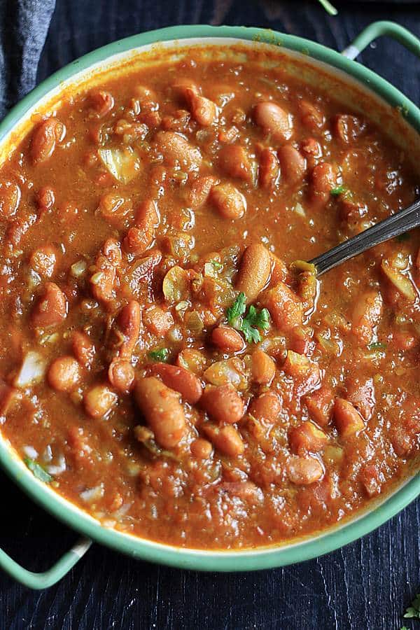 Rajma masala served in a enamel bowl with a spoon