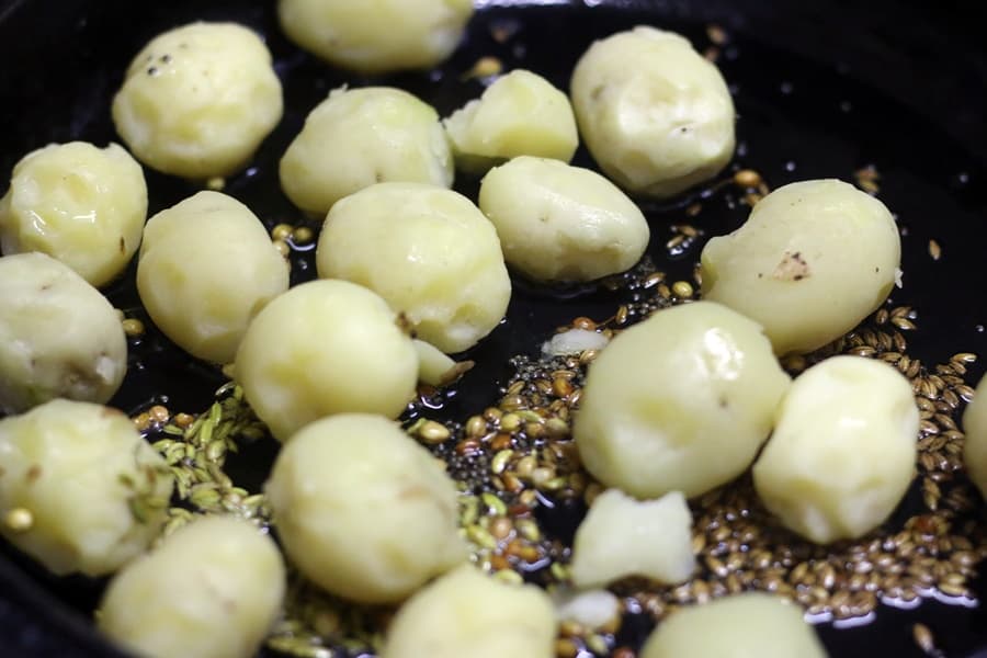 sauteing baby potatoes for making bombay potato curry