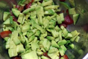 finely chopped avocado, tomatoes and onions in a bowl