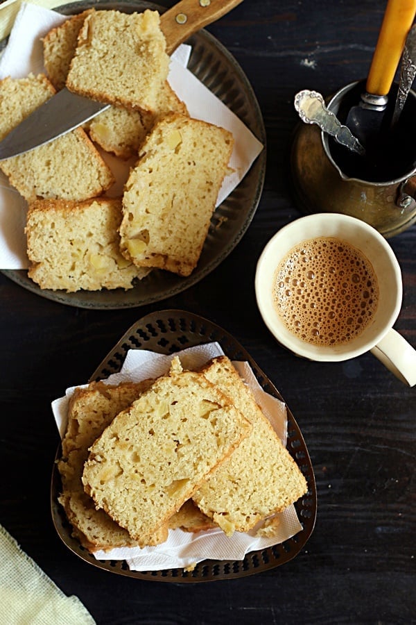 hearty slices of egg free cinnamon apple cake served in a rustic metal plate with tea for snacks