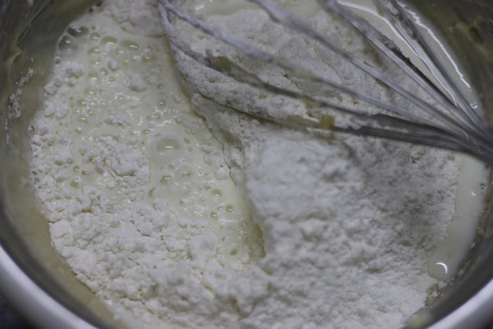 mixing dry ingredients with wet ingredients for making cream cheese cake recipe