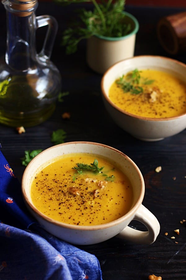 Two serving of easy and tasty pumpkin soup served in rustic white soup bowls