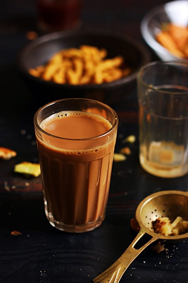 A strong cup of ginger tea or adrak chai served with savory snacks