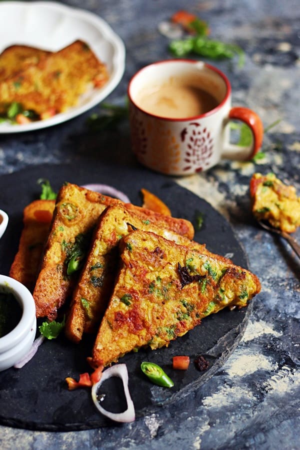 A stack of vegan savory french toasts on a black tray served with coffee for breakfast