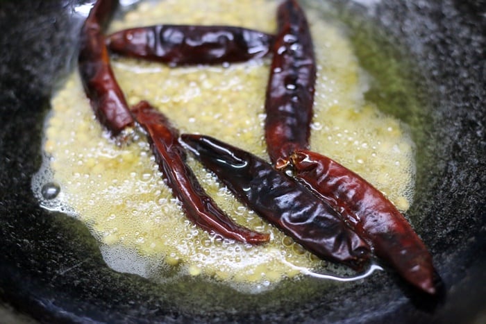 frying red chilies to make karuveppilai chutney