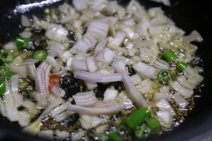 Sautéing ginger garlic, onions and chilies in oil for making paneer scramble 