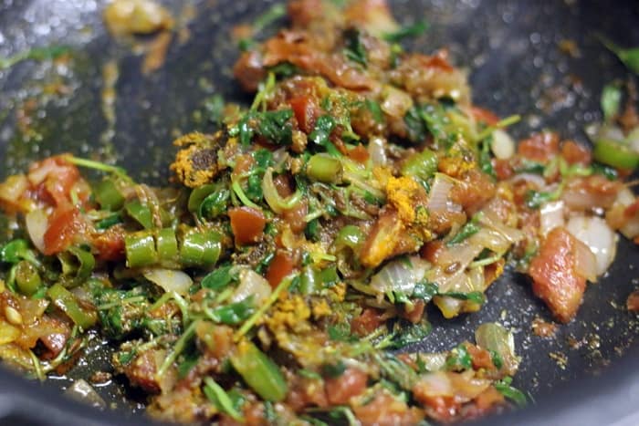 Sautéing onion tomatoes and methi leaves. 