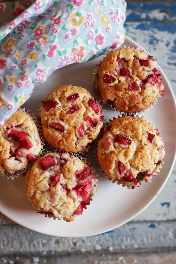 overhead shot of freshly baked strawberry muffins on a white plate.