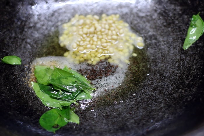 Tempering mustard seeds for making vazhakkai poriyal 