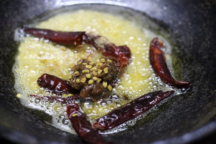 Frying urad dal, chilies and tamarind to make brinjal chutney