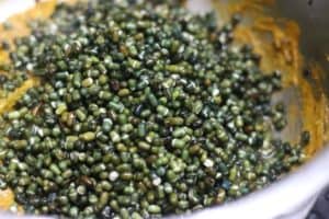 Adding soaked and drained sabut urad dal or whole black gram for making maa ki dal recipe