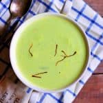 overhead shot of matar ki kheer or peas kheer served for dessert in a bowl with spoon