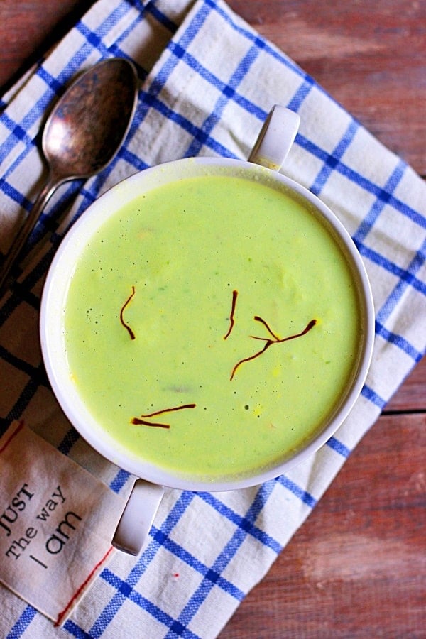 overhead shot of matar ki kheer or peas kheer served for dessert in a bowl with spoon