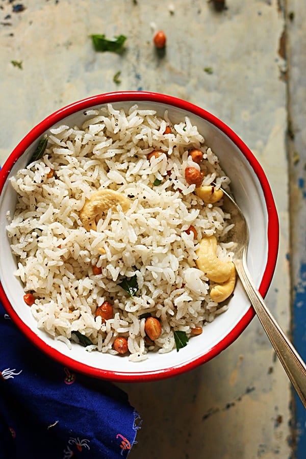 pepper rice served in a red rimmed bowl with a spoon for dinner