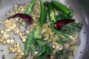 frying mustard seeds, curry leaves, chana dal, slit green chilies, dry red chilies in oil for potato masala