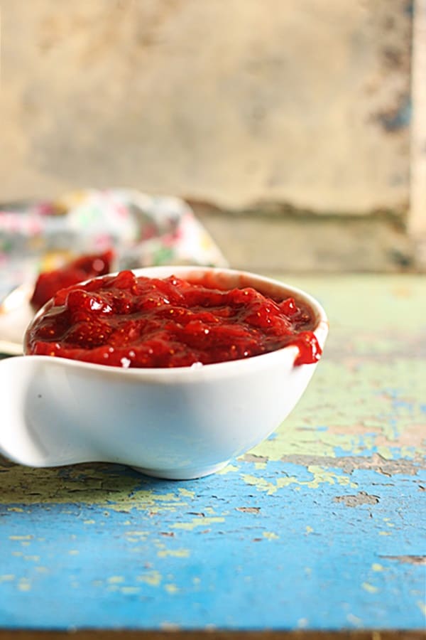 Homemade strawberry sauce served in a small white sauce bowl