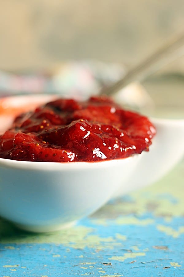 Closeup shot of fresh homemade strawberry sauce in a white sauce bowl