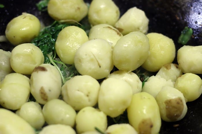 Baby potatoes added to sauteed methi leaves