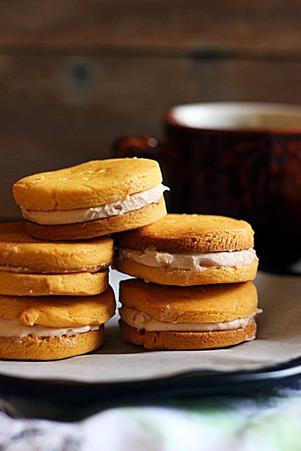 rose flavored custard creams stacked in a plate with coffee in the background