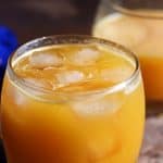 Ganga jamuna juice or orange mosambi juice served chilled with ice cubes in a glass tumbler