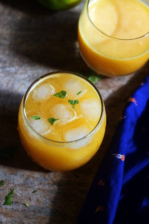 ganga jamuna juice garnished with mint leaves served in a small glass tumbler