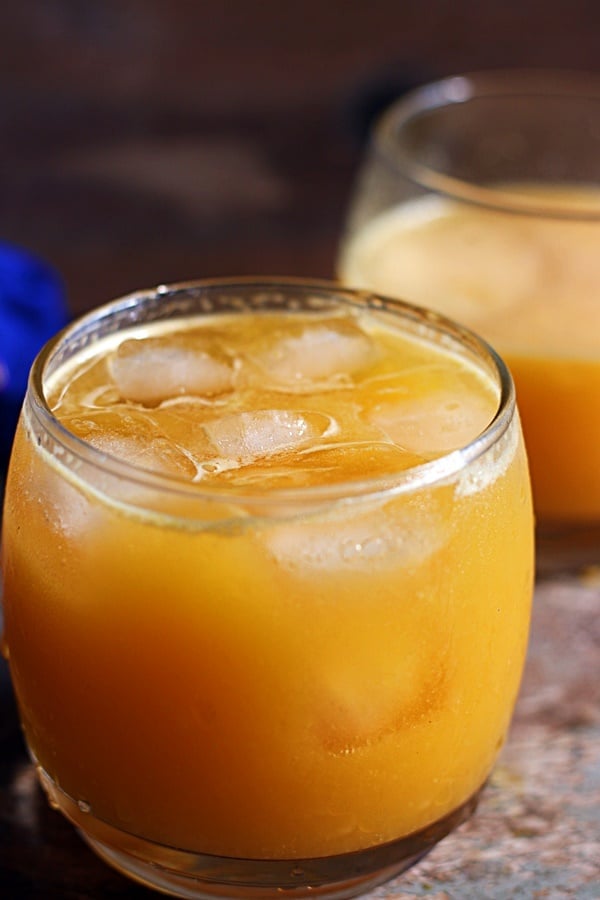 Ganga jamuna juice or orange mosambi juice served chilled with ice cubes in a glass tumbler