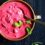 beetroot raita served in a ceramic bowl with a spoon