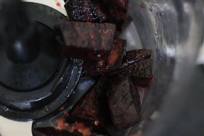 pulsing roasted beets in a food processor