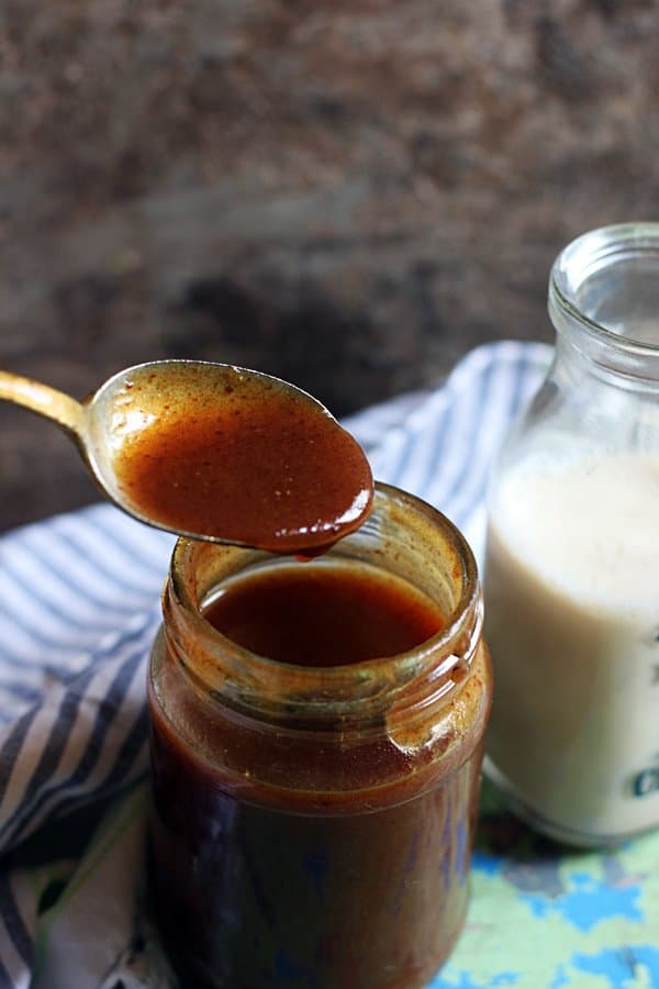 homemade date syrup in a bottle with spoon. Served with milk in a bottle