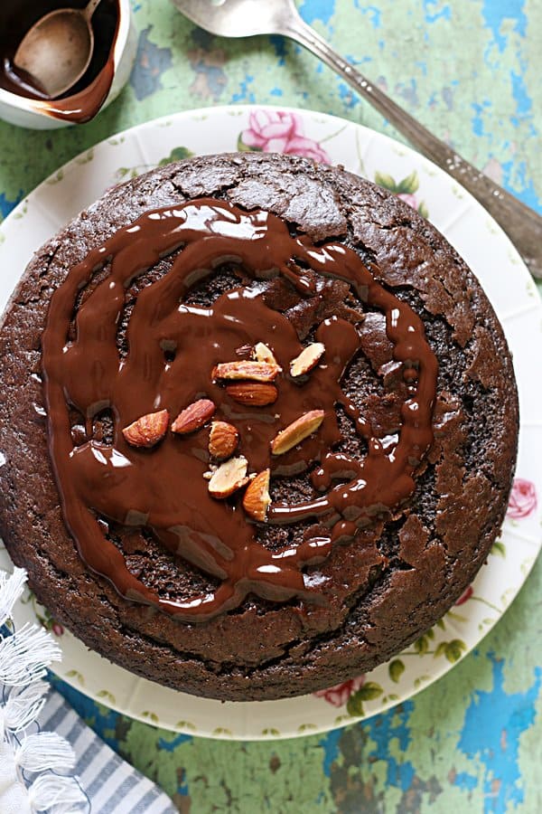 Chocolate cake drizzled with chocolate sauce and garnished with roasted almonds