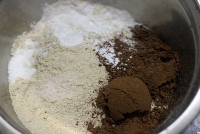 Sifting wheat flour, cocoa powder, baking powder over wet ingredients