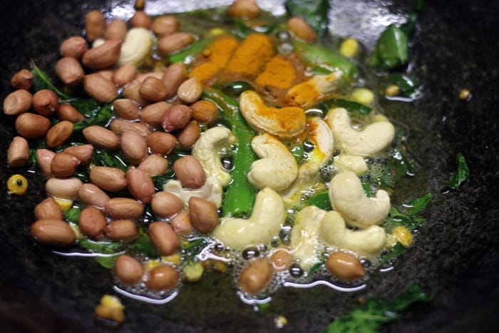 Frying peanuts, cashews and turmeric powder in oil