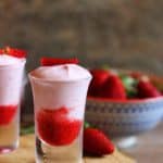 fresh strawberry mousse served in shot glasses served on a wooden tray.